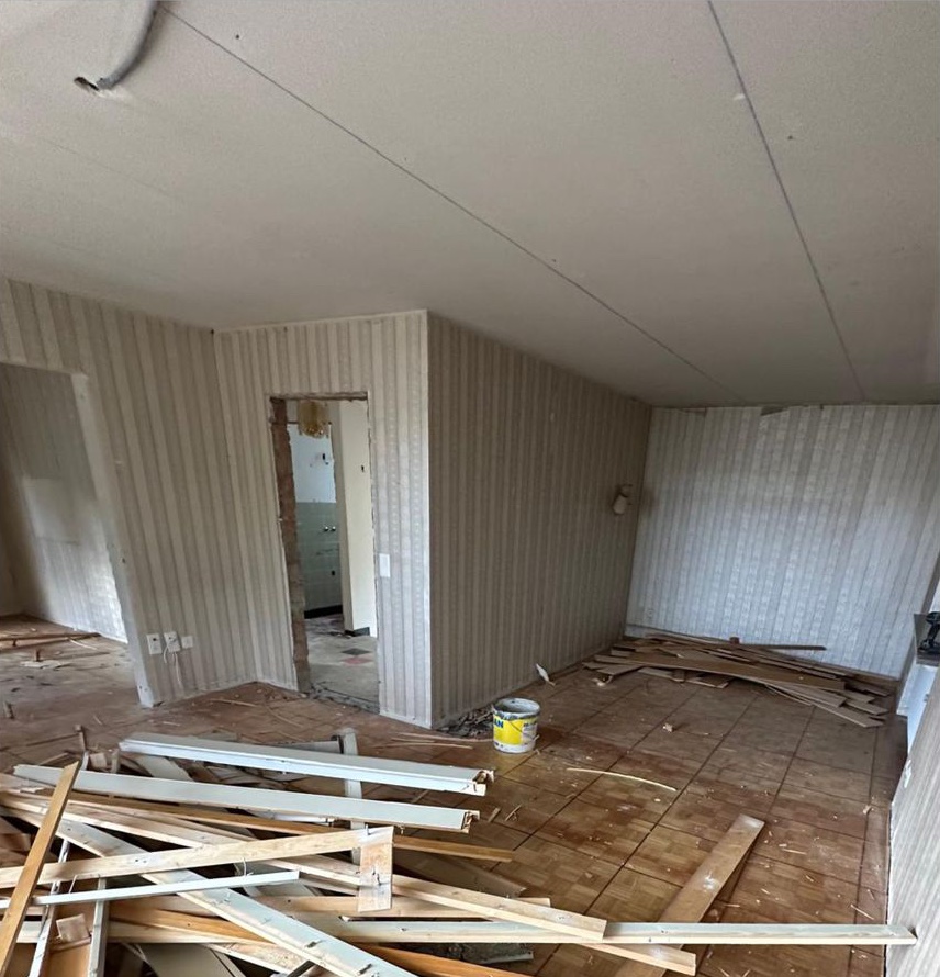 Vorher: derselbe Raum mit Tapete, altem Boden und Abbruchholz